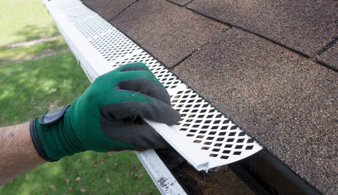 Professional installing Gutter guards in gutter.